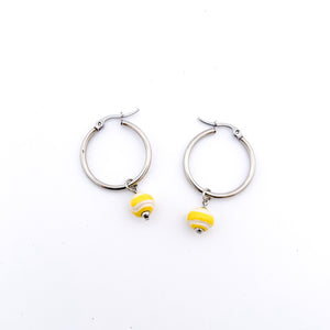 yellow ceramic tennis ball bead charms dangling from stainless steel hoop earrings