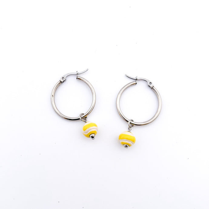 yellow ceramic tennis ball bead charms dangling from stainless steel hoop earrings