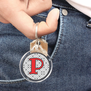 close up of a personalized acrylic keychain featuring red and grey initial P