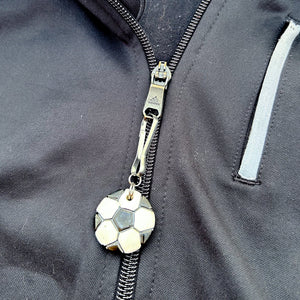 ceramic soccer ball zipper pull hanging from a black jacket