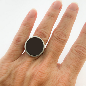 close up of hand wearing a stainless steel and black statement ring