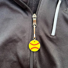 ceramic softball zipper pull hanging from a black jacket