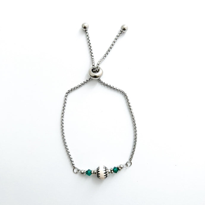 stainless steel adjustable bracelet with a ceramic baseball bead and green swarovski crystal beads