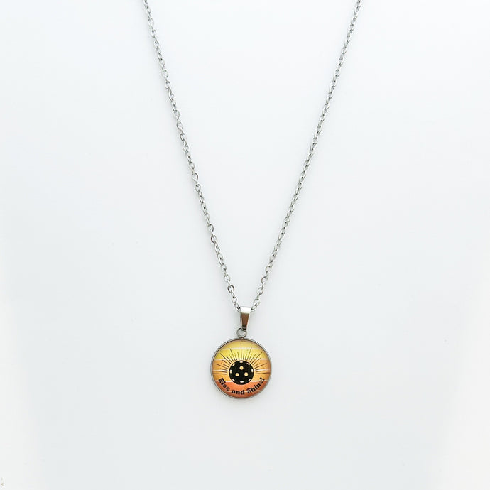 stainless steel pickleball necklace with yellow and orange rise and shine grahpic