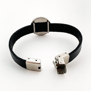 back view of black leather strap bracelet with open stainless steel clasp and slide charm