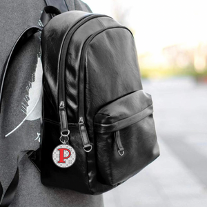 mock up of personalized acrylic photo keychain hanging from a black leather backpack