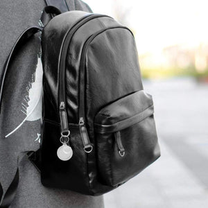 close up of black backpack and acrylic photo keychain accessory