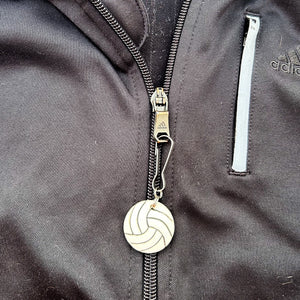 ceramic volleyball zipper pull hanging from a black jacket