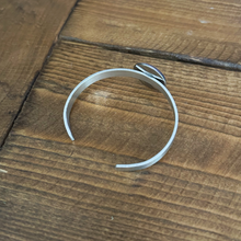 back view of an aluminum cuff bracelet with cabochon charm