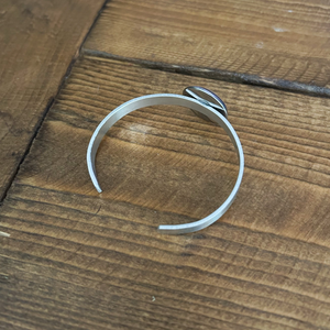 back view of an aluminum cuff bracelet with cabochon charm