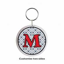 personalized acrylic photo keychain with red initial letter M with black pattern background