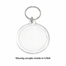 Clear round acrylic photo keychain with stainless steel key ring against a white background 
