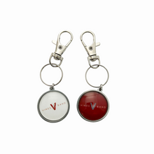 two stainless steel circular keychains featuring the Vines High School Band logo in white and maroon with swivel clip attachment
