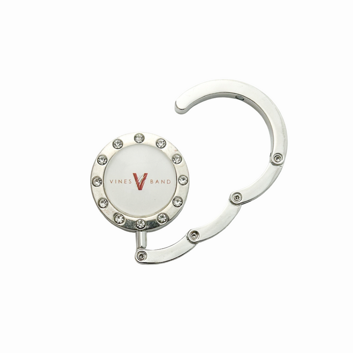 silver circular purse hook with crystal rhinestones featuring a center cabochon with the Vines Band V logo in white