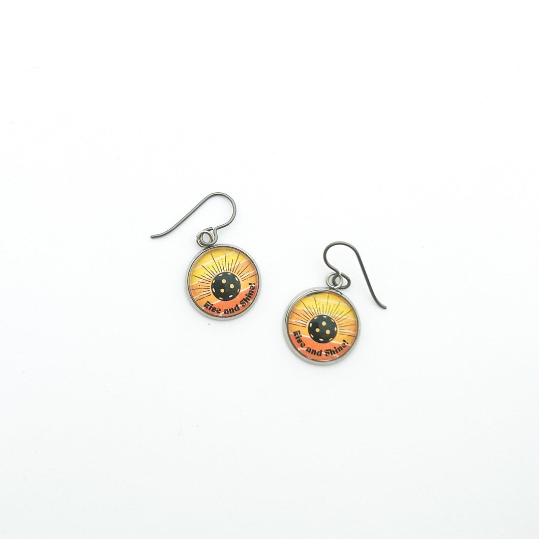 stainless steel pickleball charm earrings with yellow and orange Rise and Shine graphic