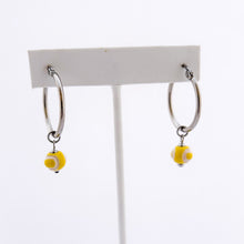 yellow ceramic tennis ball bead charms dangling from stainless steel hoop earrings