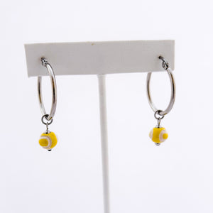 yellow ceramic tennis ball bead charms dangling from stainless steel hoop earrings
