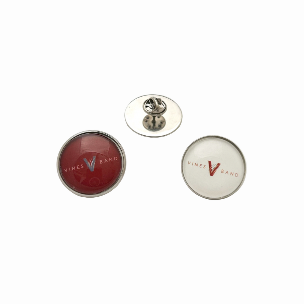 Two circular stainless steel pins with 'Vines Band' logo in maroon and white