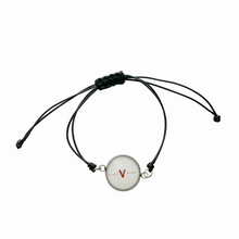 black adjustable cord Bracelet with a circular charm featuring the vines band logo in white