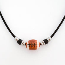 ceramic football bead necklace with black tube bead and stainless steel spacer beads accents strung on a black cotton cord