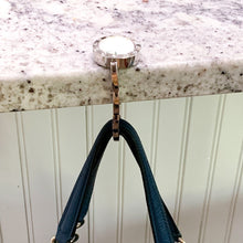 purse hook hanging from granite countertop