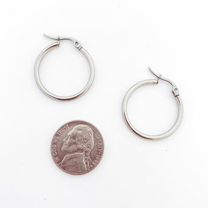 stainless steel hoop earrings with a nickel for size comparison