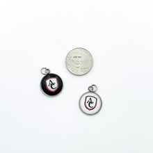 custom stainless steel cabochon charms featuring the Archbishop Curley high school logo in white and black compared to a nickel