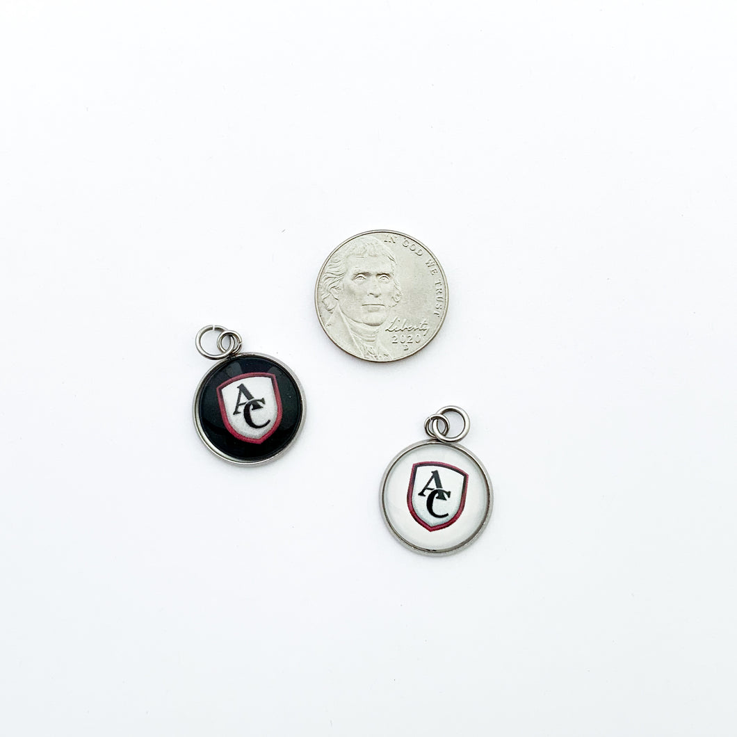 custom stainless steel cabochon charms featuring the Archbishop Curley high school logo in white and black compared to a nickel