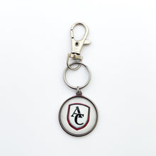 custom stainless steel round keychain with the Archbishop Curley high school logo in white and a stainless steel swivel clip