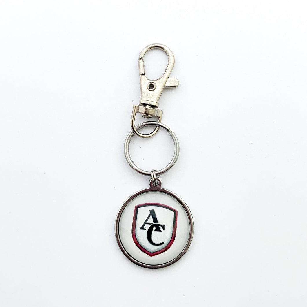 custom stainless steel round keychain with the Archbishop Curley high school logo in white and a stainless steel swivel clip