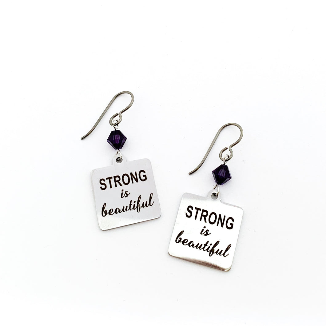 stainless steel charm earrings with laser engraved with Strong is Beautiful accented with 6 mm purple Swarovski crystal bicone beads